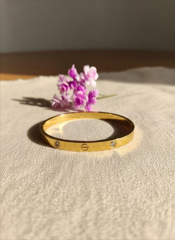 Elegant gold plated bracelet for women on fabric background – daily wear jewellery